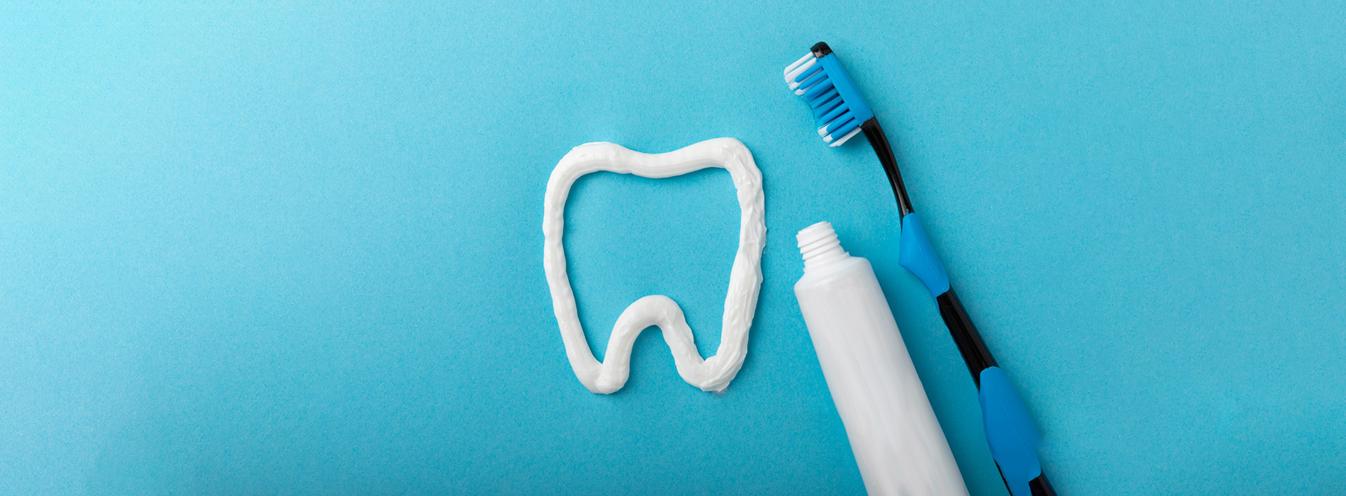 This is an image of a toothbrush with toothpaste on a teal background.