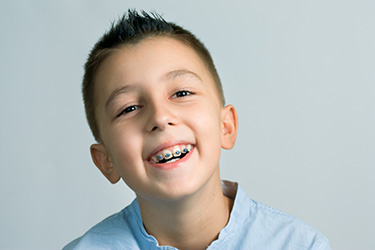 Boy with braces smiling at camera.